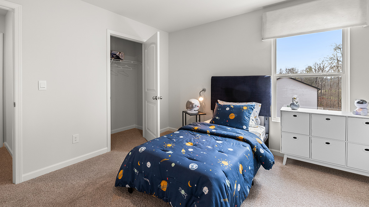 Secondary bedroom in Hanover Plan with closet storage crafted by D.R. Horton in Dallas Georgia with, blue bed with a window