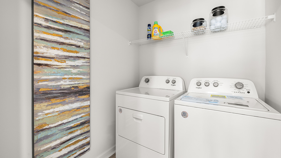 Laundry room in Hanover Plan New Home by D.R. Horton with dedicated appliance space and overhead shelving in Lost Creek