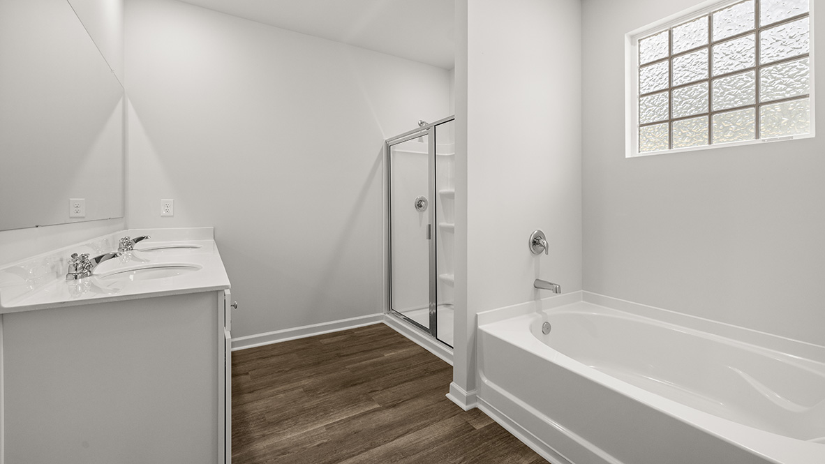 Interior primary bathroom with double sink, shower and bath tub
