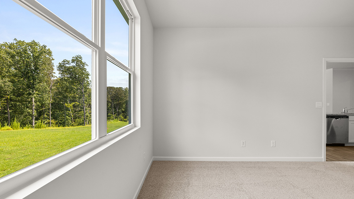 Bright and open primary bedroom in Lost Creek with neutral paint and large window overlooking backyard