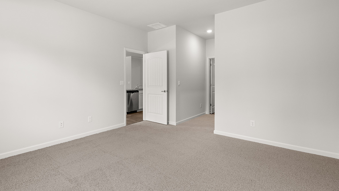 Bright and open primary bedroom in Lost Creek with neutral paint and large window overlooking backyard