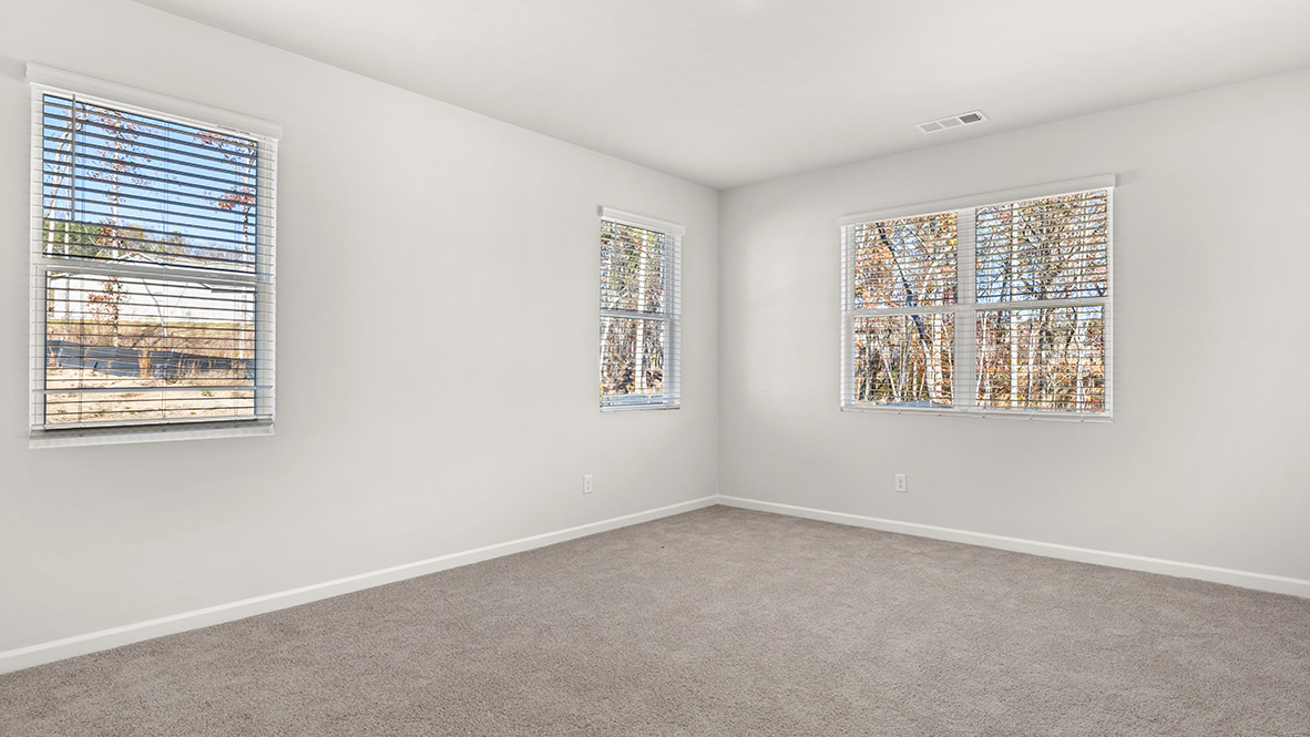 Interior primary bedroom with large windows