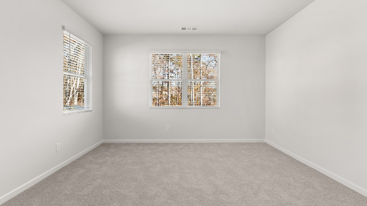 Interior primary bedroom with large windows