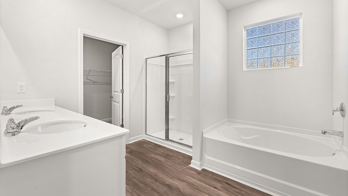 Interior primary bathroom with double sink, bath tub and shower