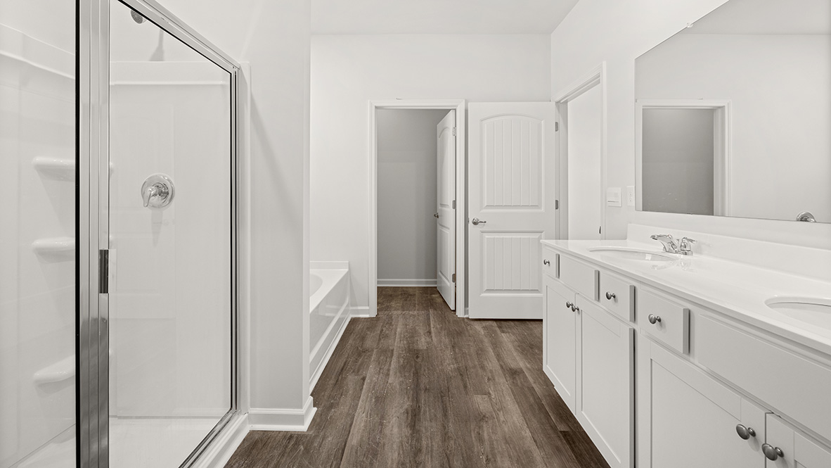 Interior primary bathroom with double sink, bath tub and shower