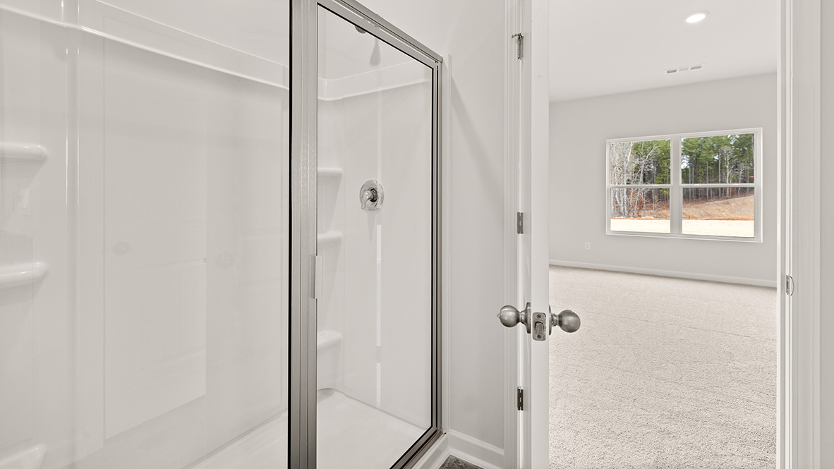 Primary bathroom featuring dual-sink vanity, white cabinetry, and access to a walk-in closet.