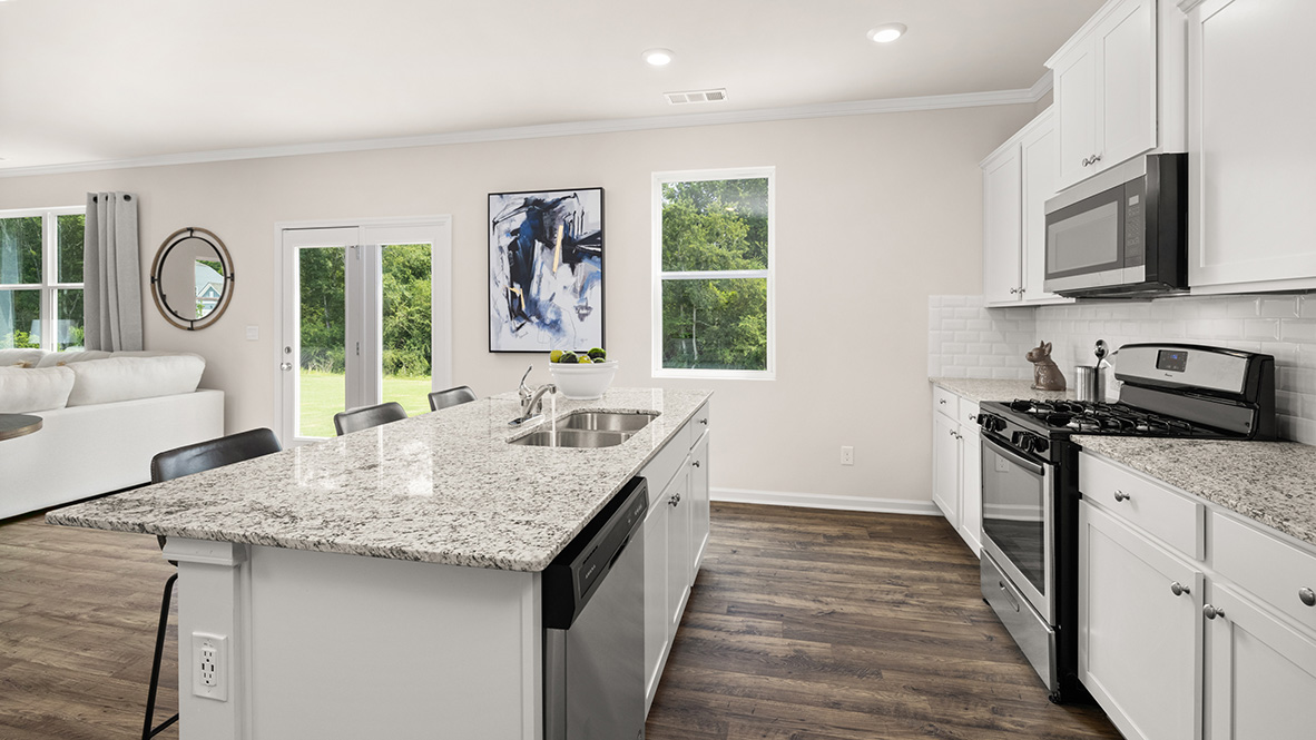 Interior kitchen with white cabinets and large windows open to dining area