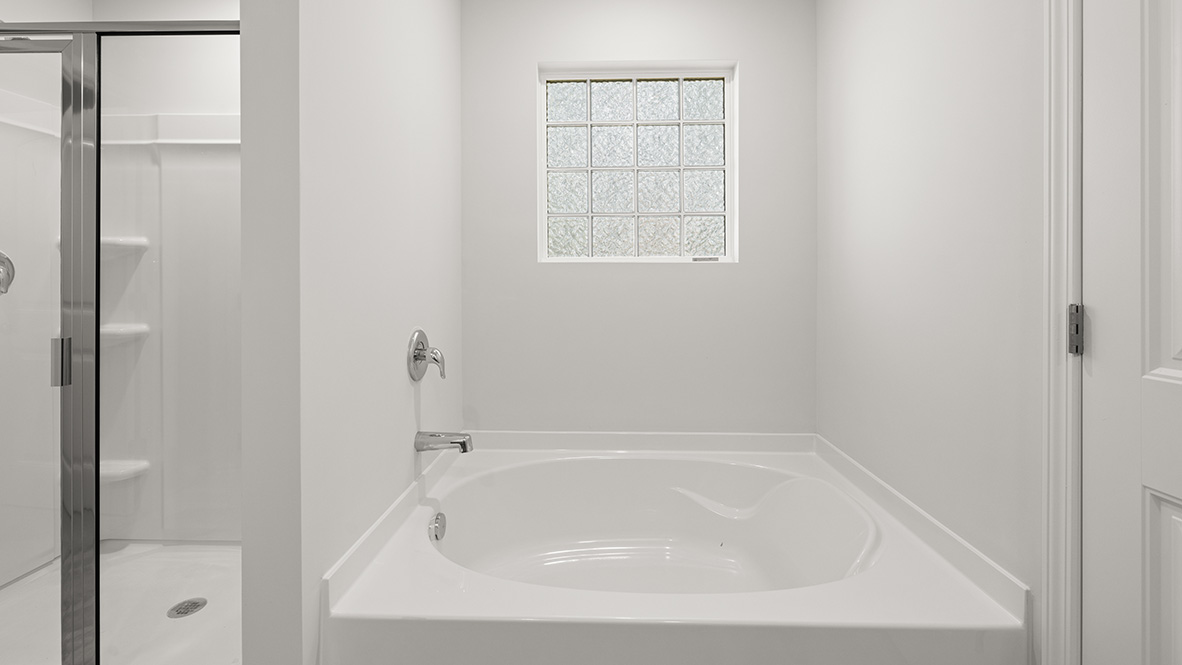 Interior primary bathroom with bath tub and shower