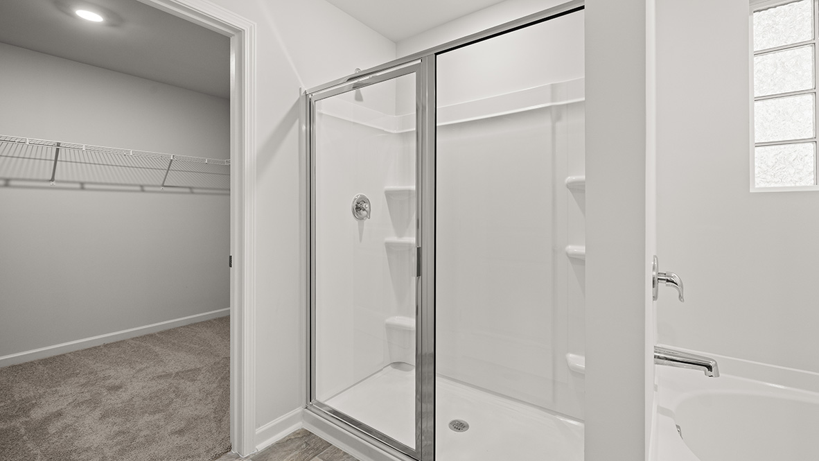 Interior primary bathroom with shower and walk-in closet