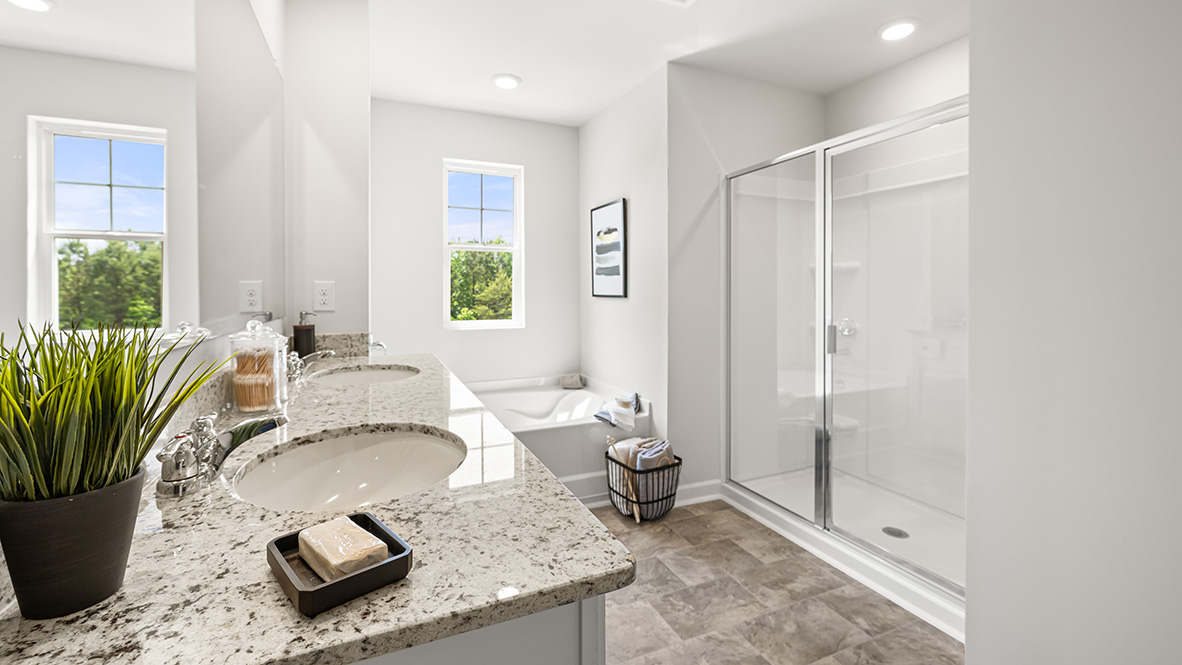 Interior primary bathroom with double sink, bath tub and shower