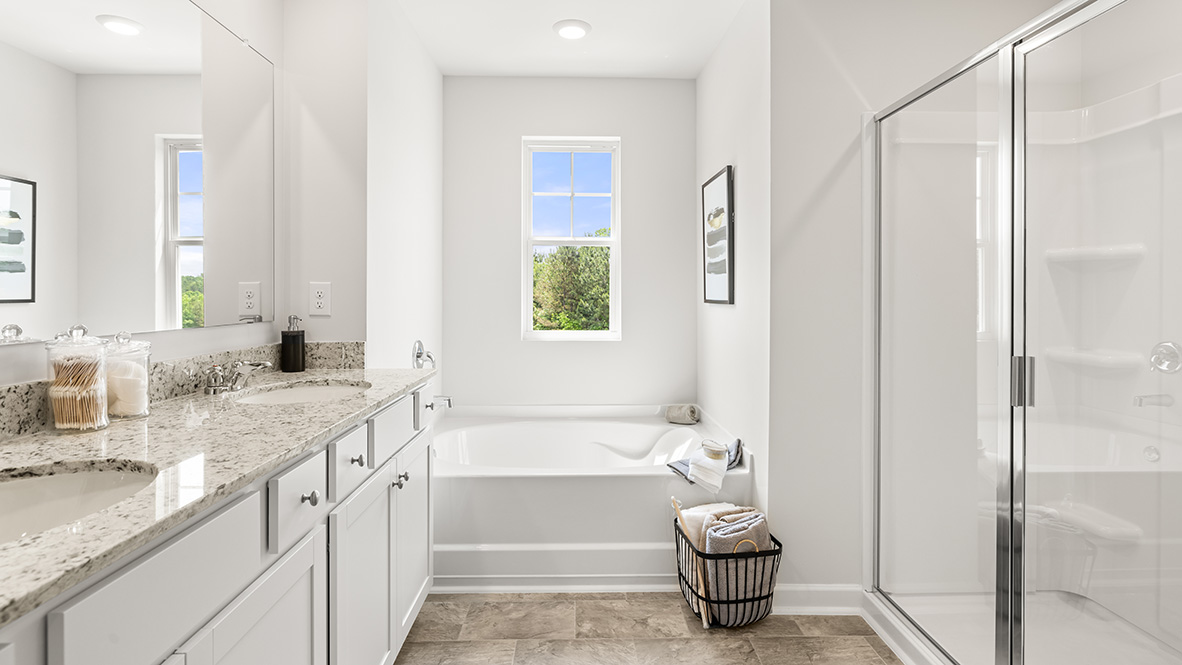 Interior primary bathroom with double sink, bath tub and shower
