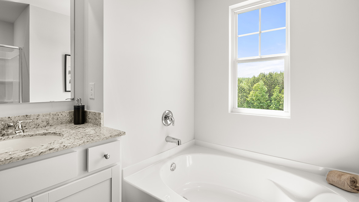 Interior primary bathroom with double sink and bath tub