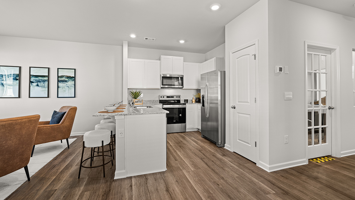 Interior kitchen with white cabinets and open to living area