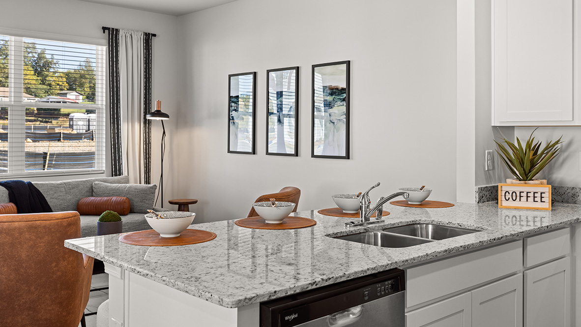 Interior kitchen with white cabinets and open to living area