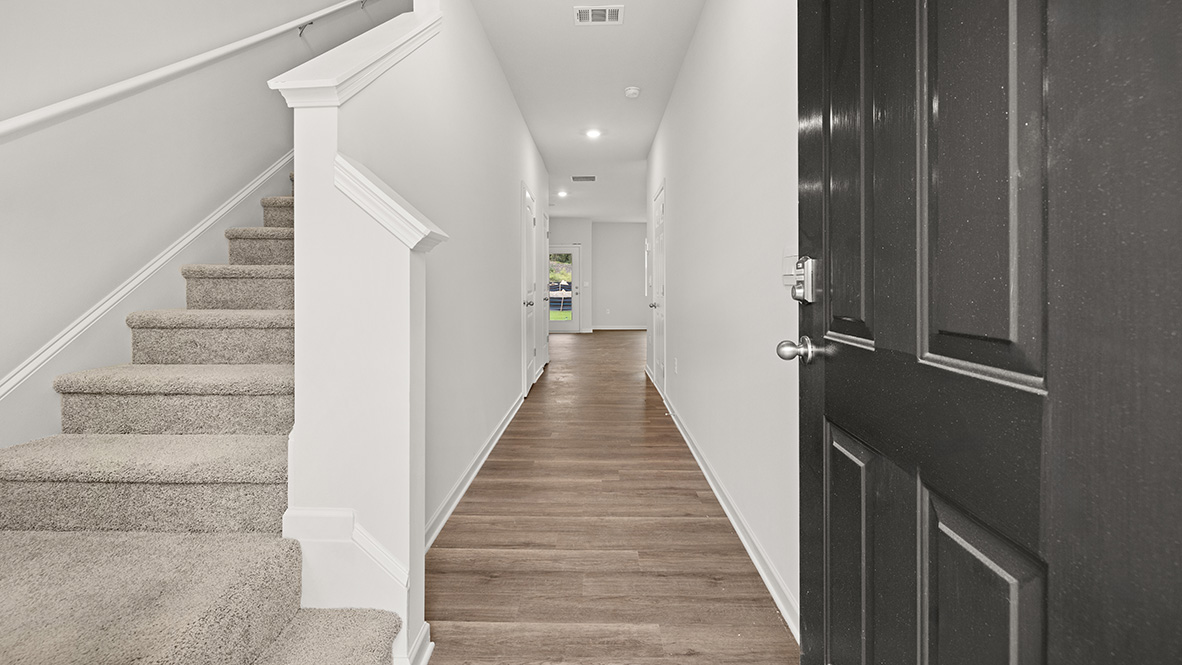 Interior entry-way open to staircase and leading to living area