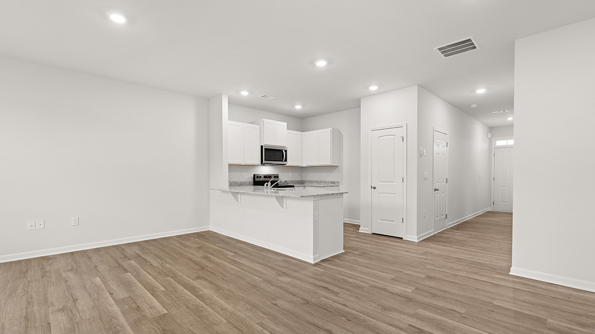 Interior living area open to kitchen with white cabinets