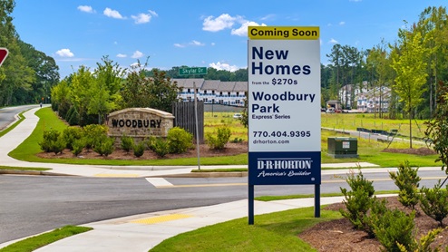 Street view in front of community with new homes sign