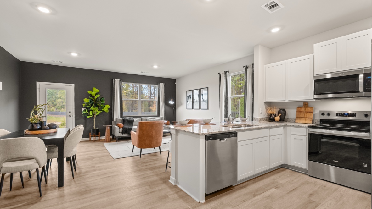 Interior kitchen with white cabinets open to living area