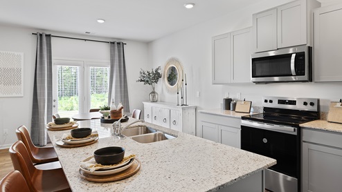hayden model home kitchen with granite countertops, stainless-steel appliances, and a breakfast area