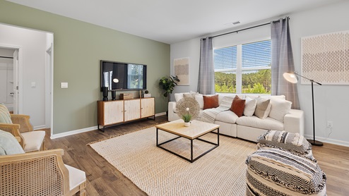 hayden model home living room with hardwood flooring and large windows