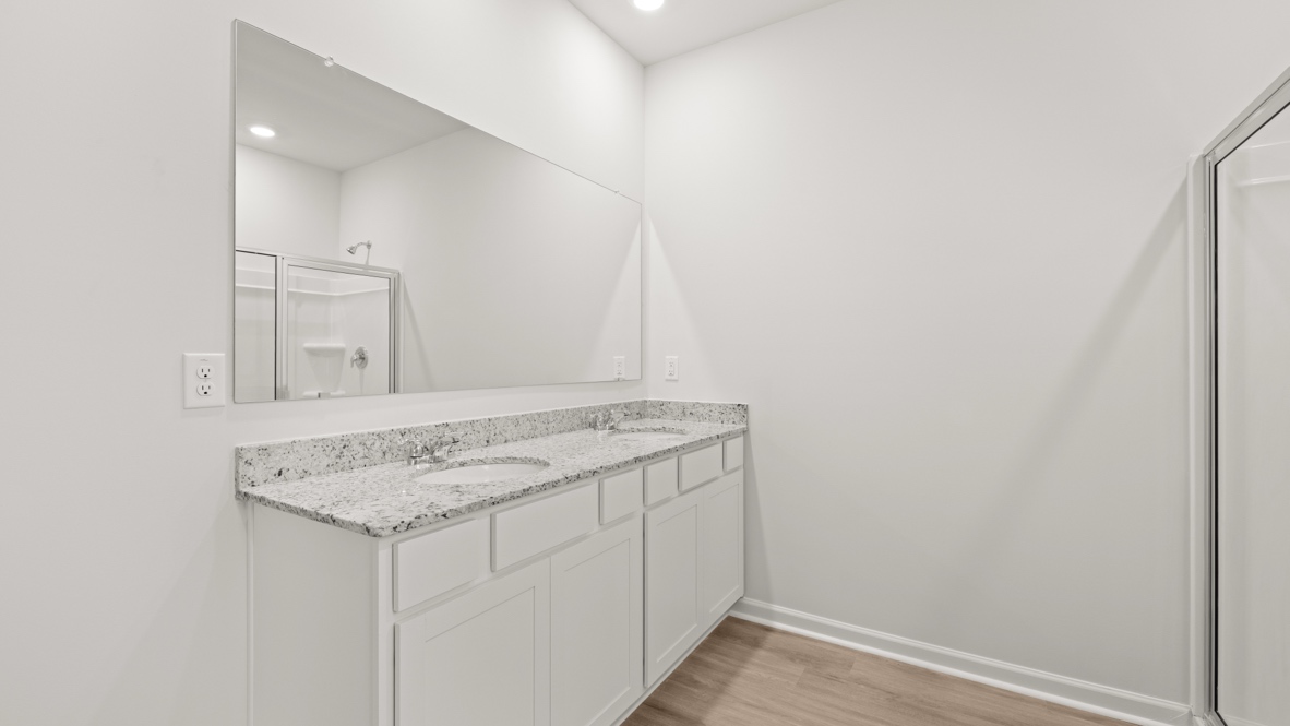 Interior primary bathroom with double sink and shower