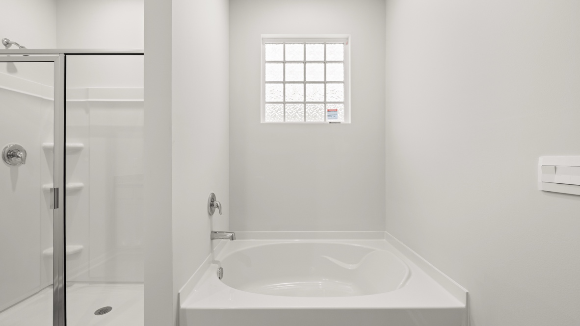 Interior primary bathroom with shower and bath tub