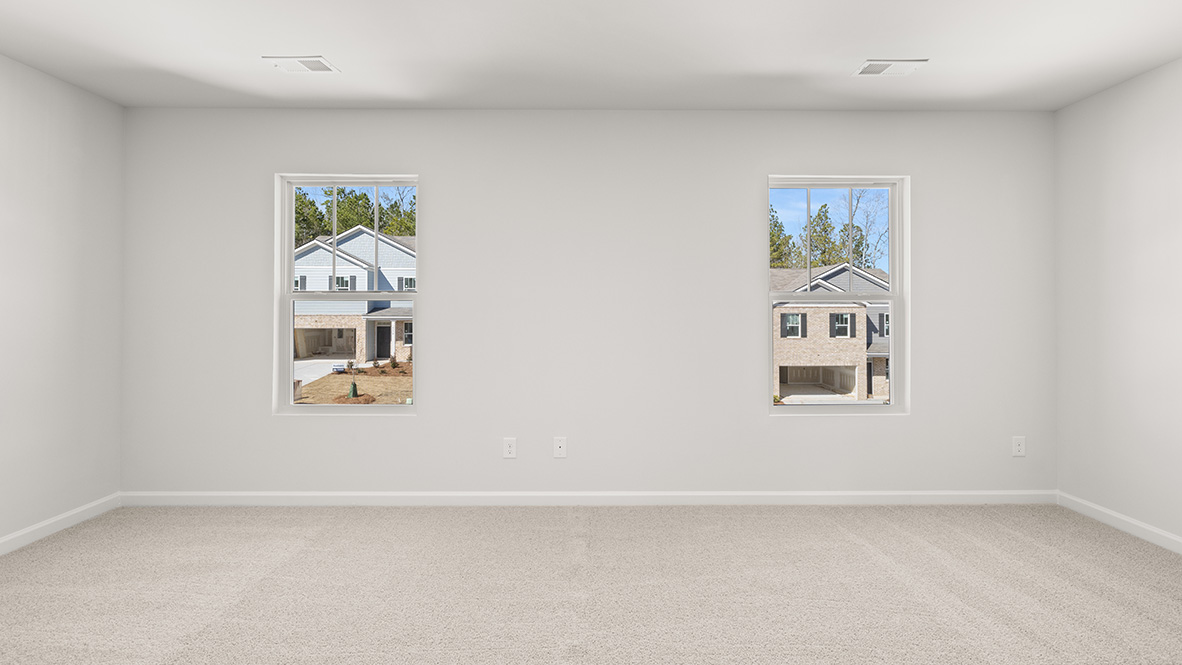 Interior primary bedroom with large windows