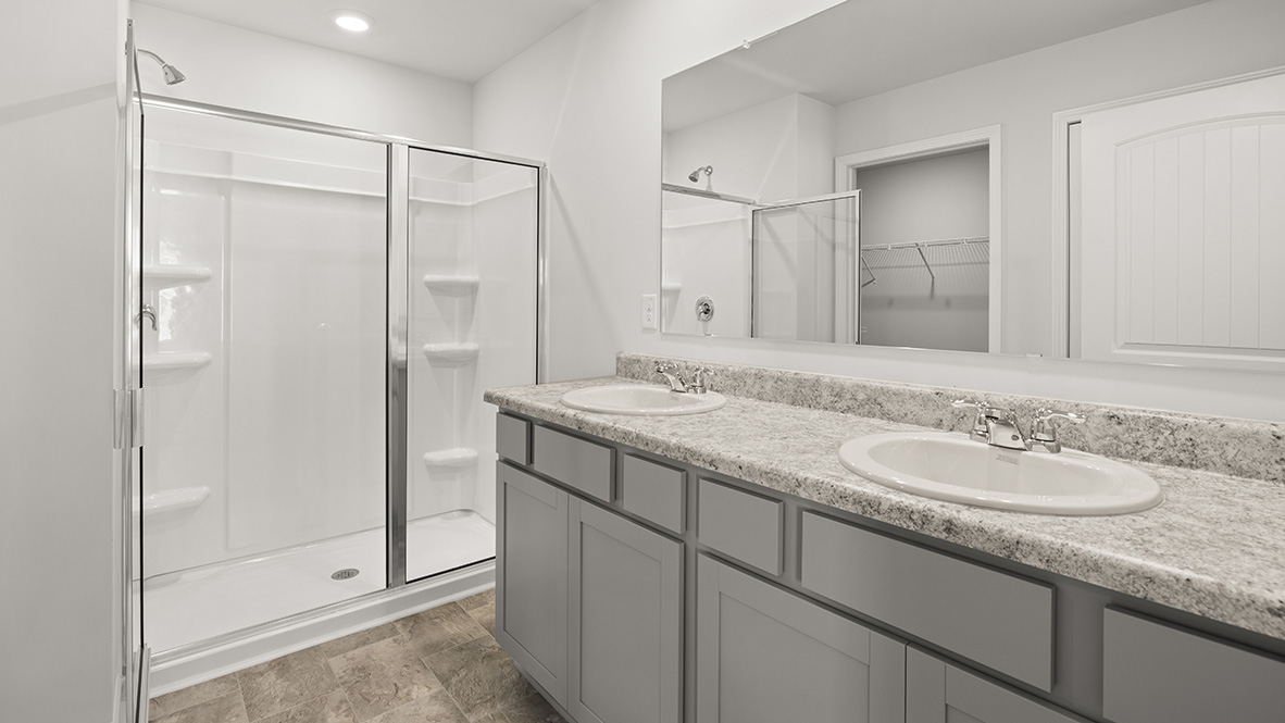 Interior primary bedroom with double sink and shower