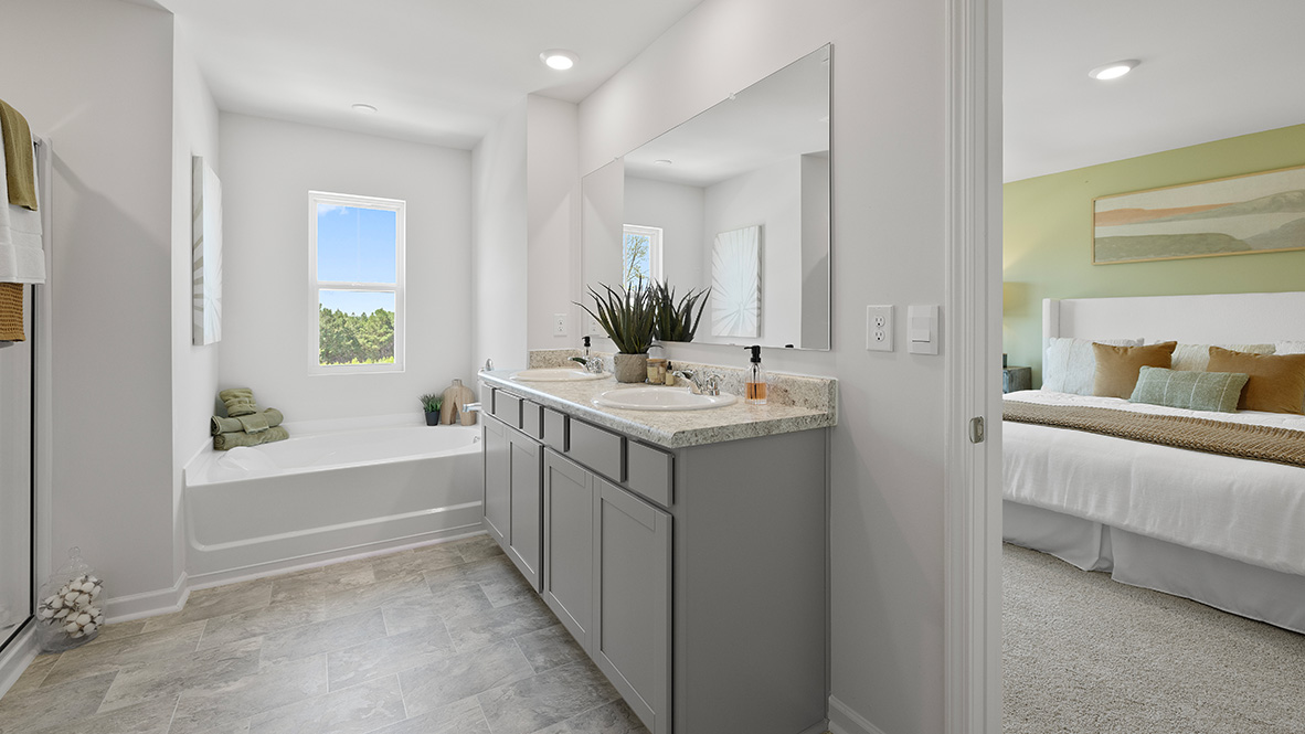 Interior primary bathroom with double sink and bath tub