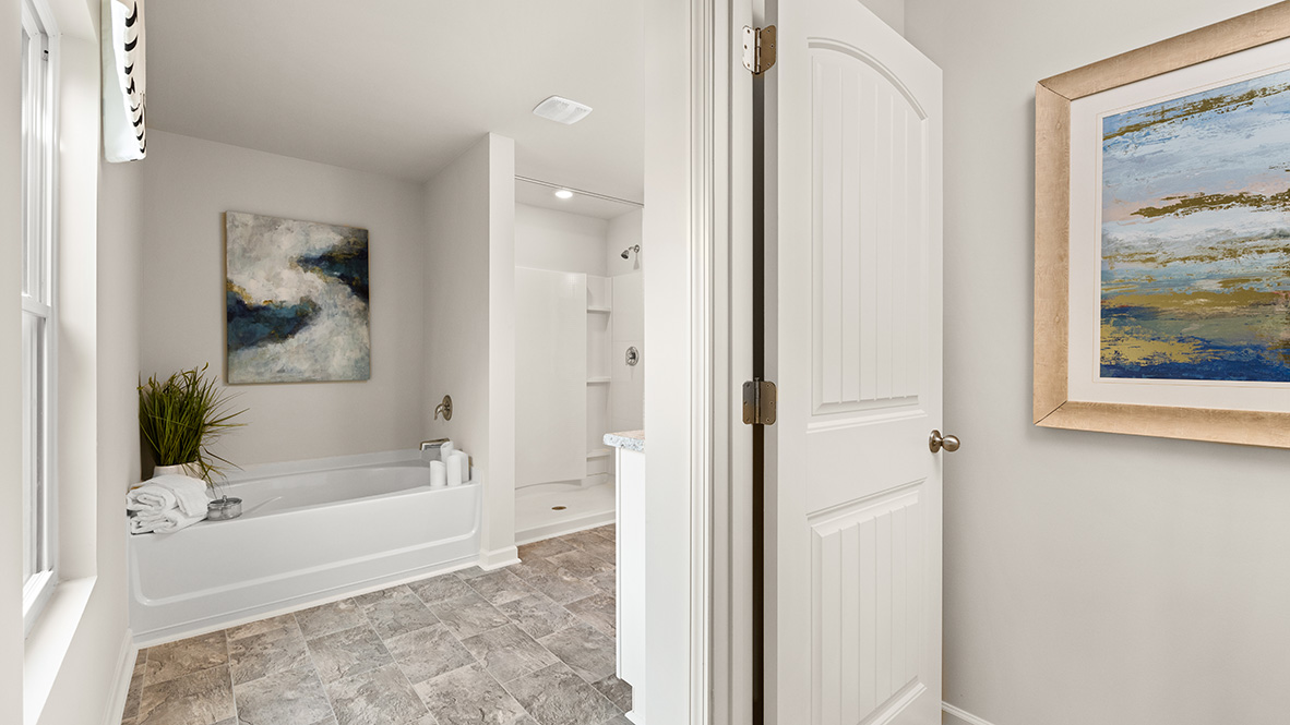 Interior primary bathroom with bath tub and shower