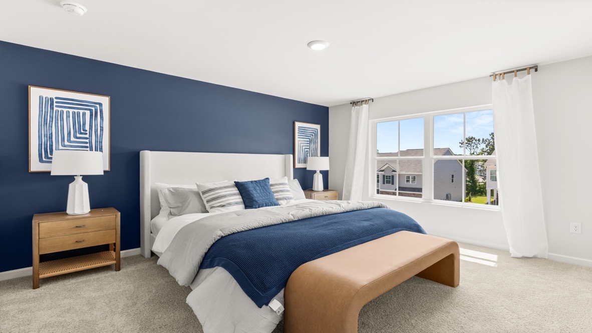 Interior primary bedroom with large window and accent wall