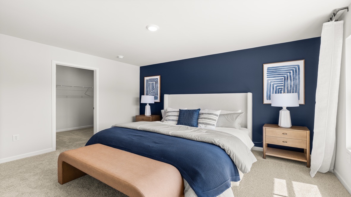 Interior primary bedroom with large window and accent wall