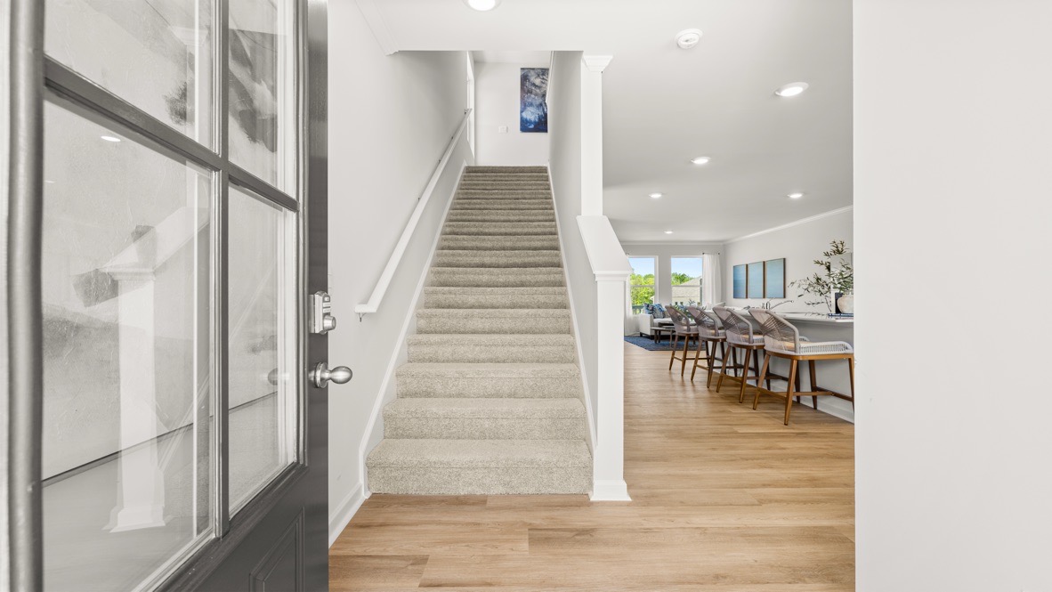 Interior entry-way open to staircase and leading to living area