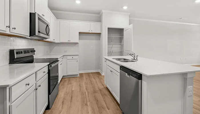 Interior kitchen with center island and white cabinets
