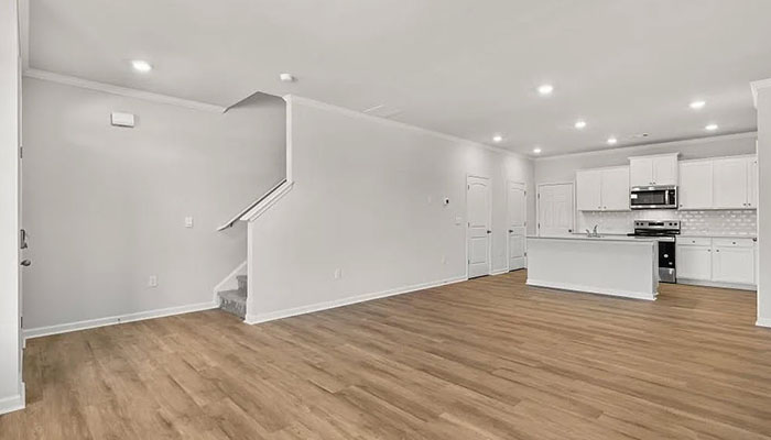 Interior living area open to staircase and kitchen with center island