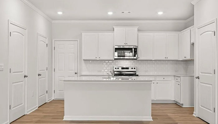 Interior kitchen with center island and white cabinets