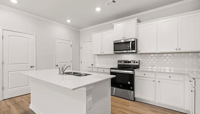 Interior kitchen with center island and white cabinets