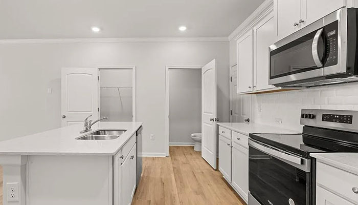 Interior kitchen with center island and white cabinets
