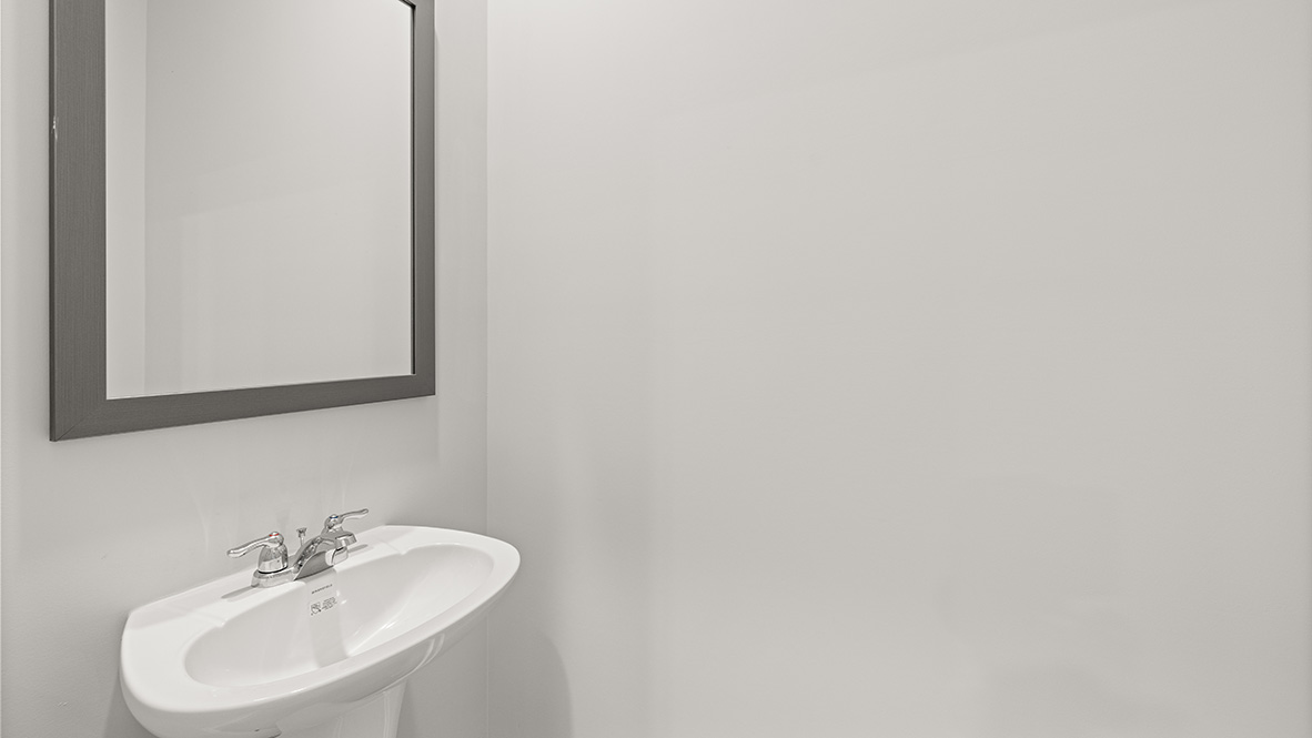 Powder bathroom with a pedestal sink and mirror