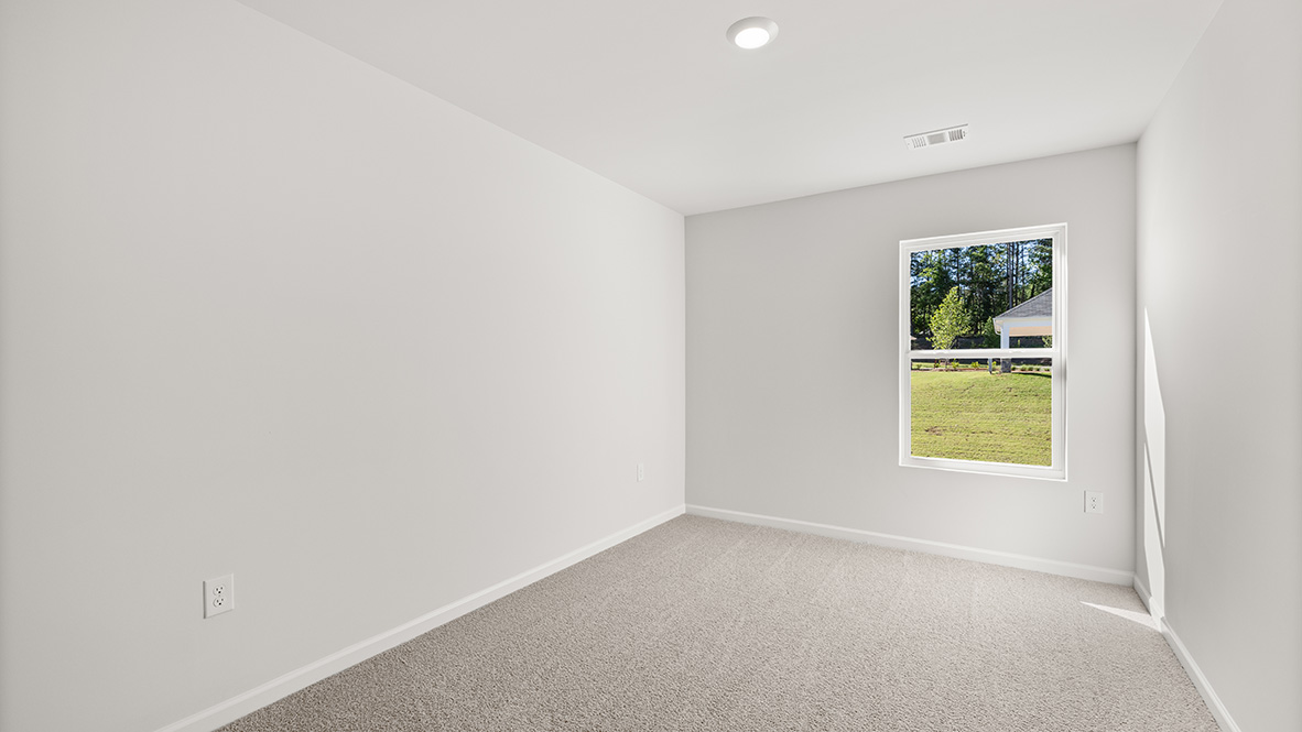 bedroom with beige carpet, white walls and a window