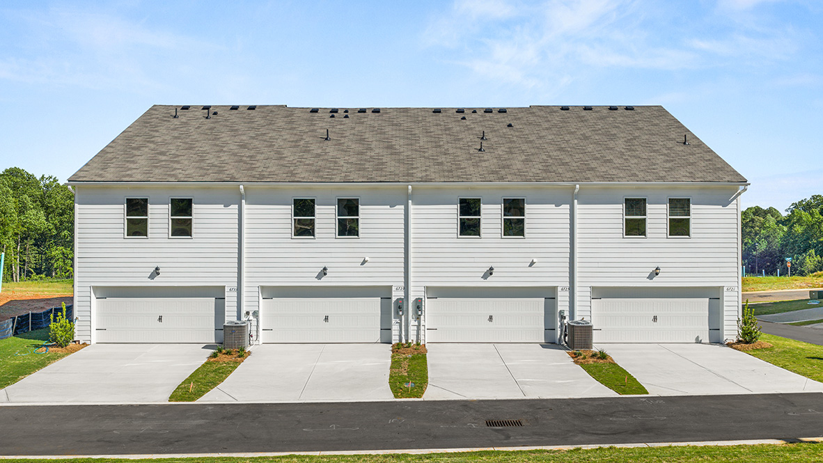 rear exterior of townhomes featuring a two car garage