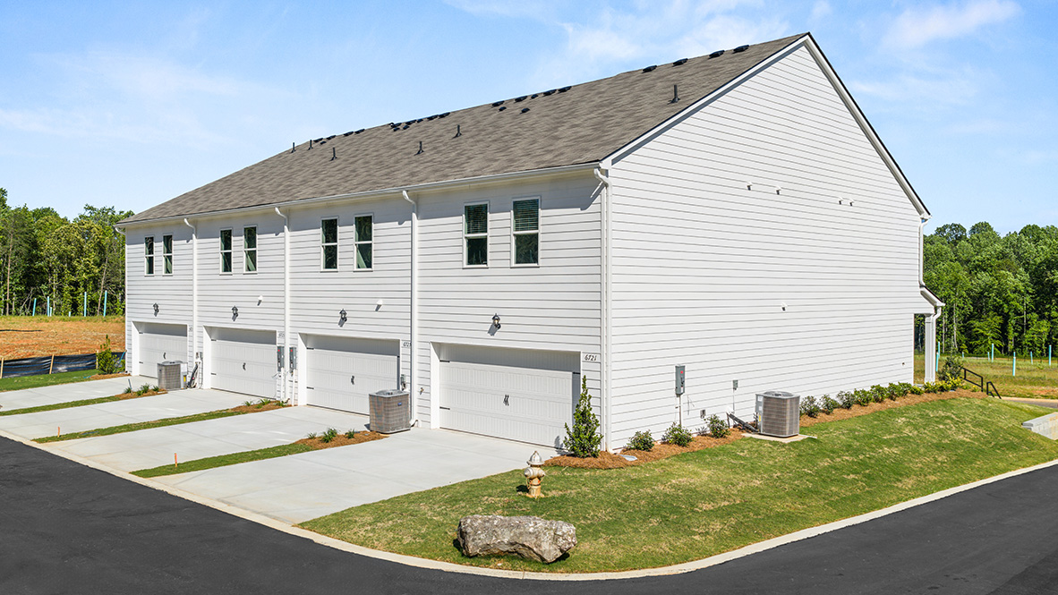 rear exterior of townhomes featuring a two car garage