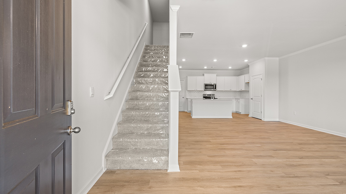 front entry way of home featuring brown flooring and white walls