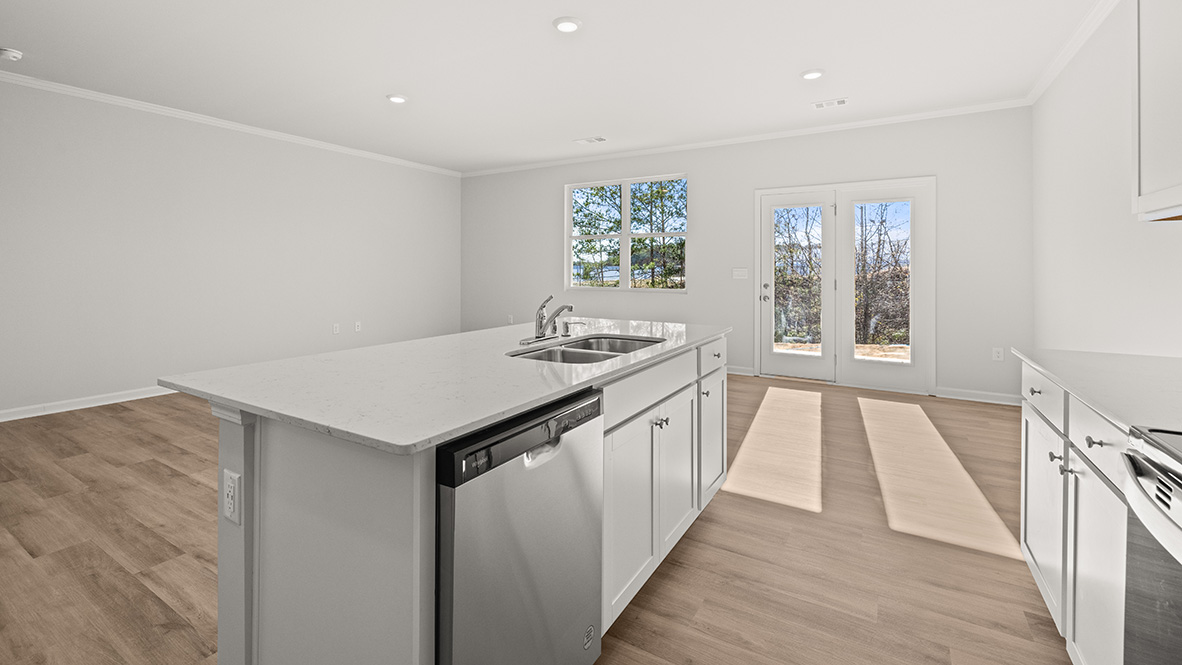 gorgeous modern kitchen with white tile backsplash, white cabinetry, large island and stainless steel appliances