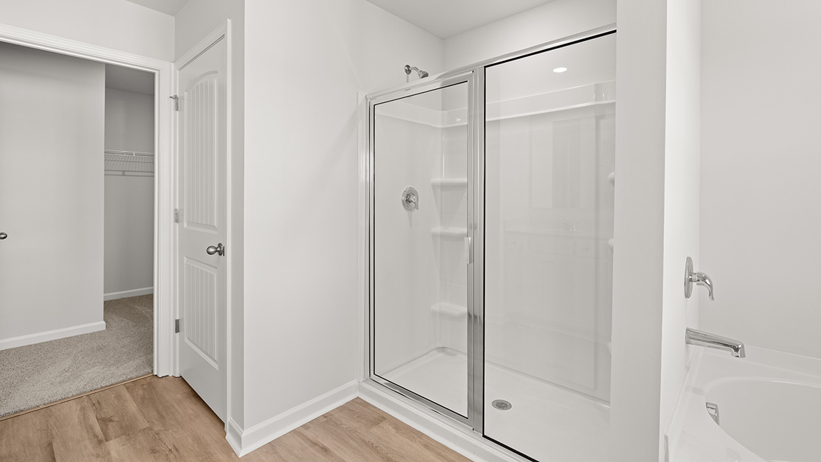 Interior primary bathroom with walk-in closet and shower