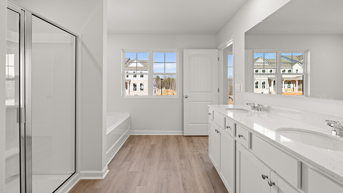 Interior primary bathroom with double sink, shower and bath tub