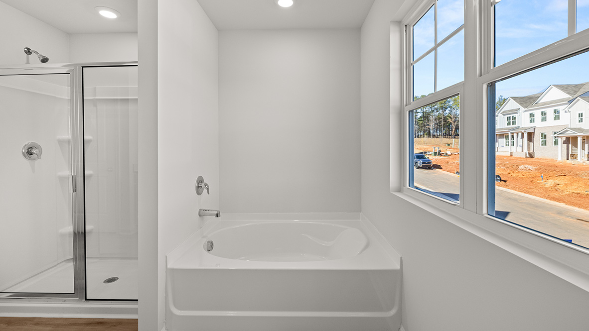 Interior primary bathroom with shower and bath tub