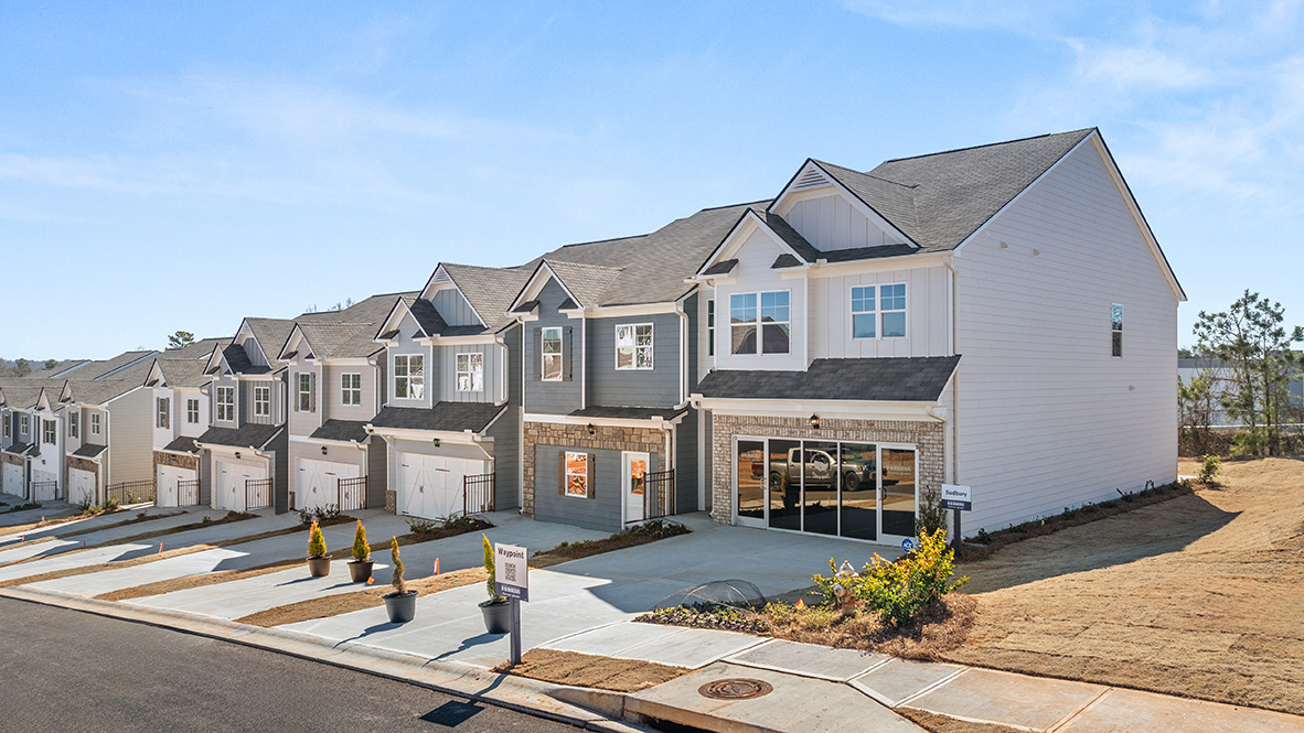 front exterior view of blue grey and white townhomes with brick accents