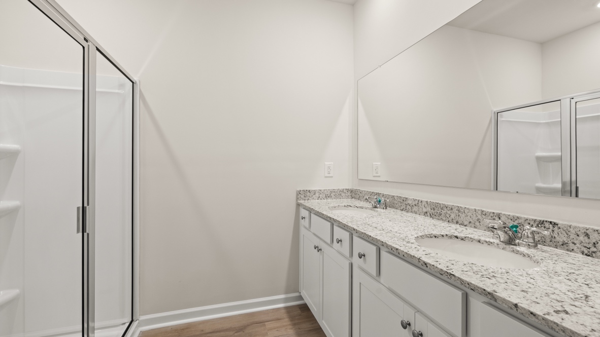 Interior primary bathroom with shower and double sink