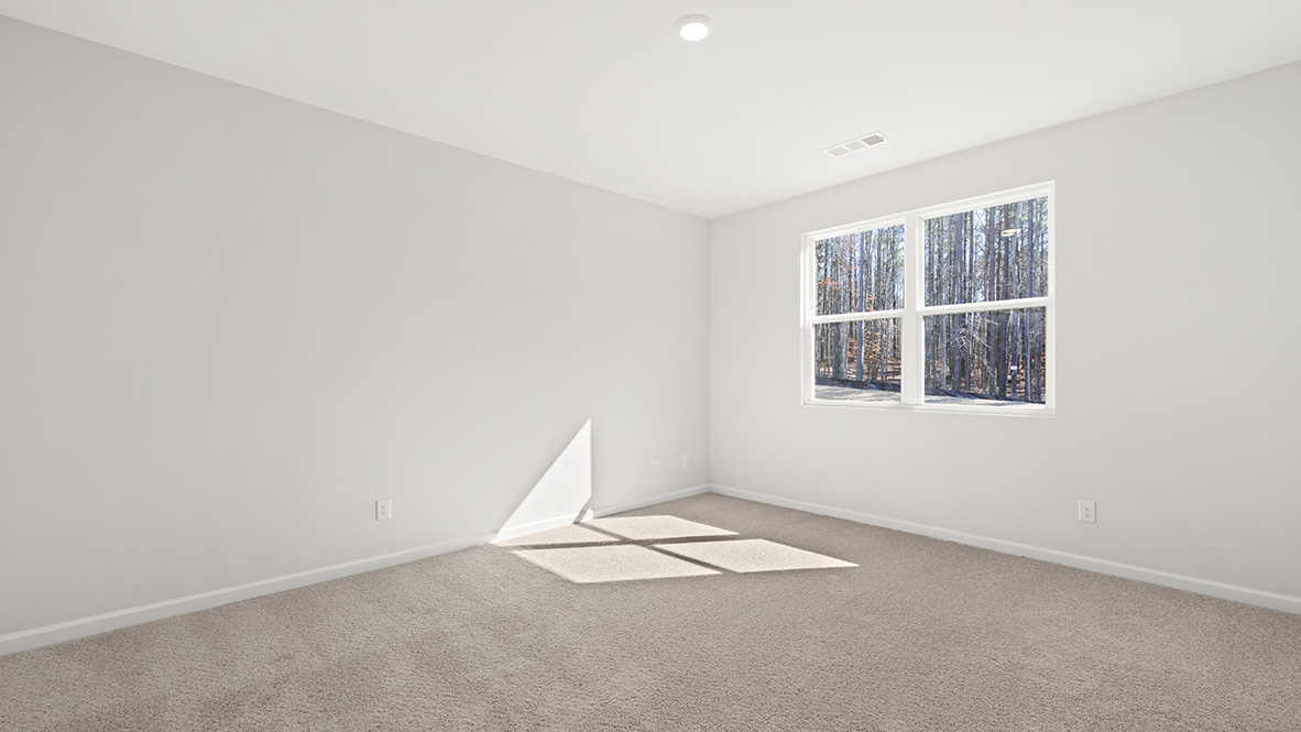 The bedroom has neutral carpet and a double window.
